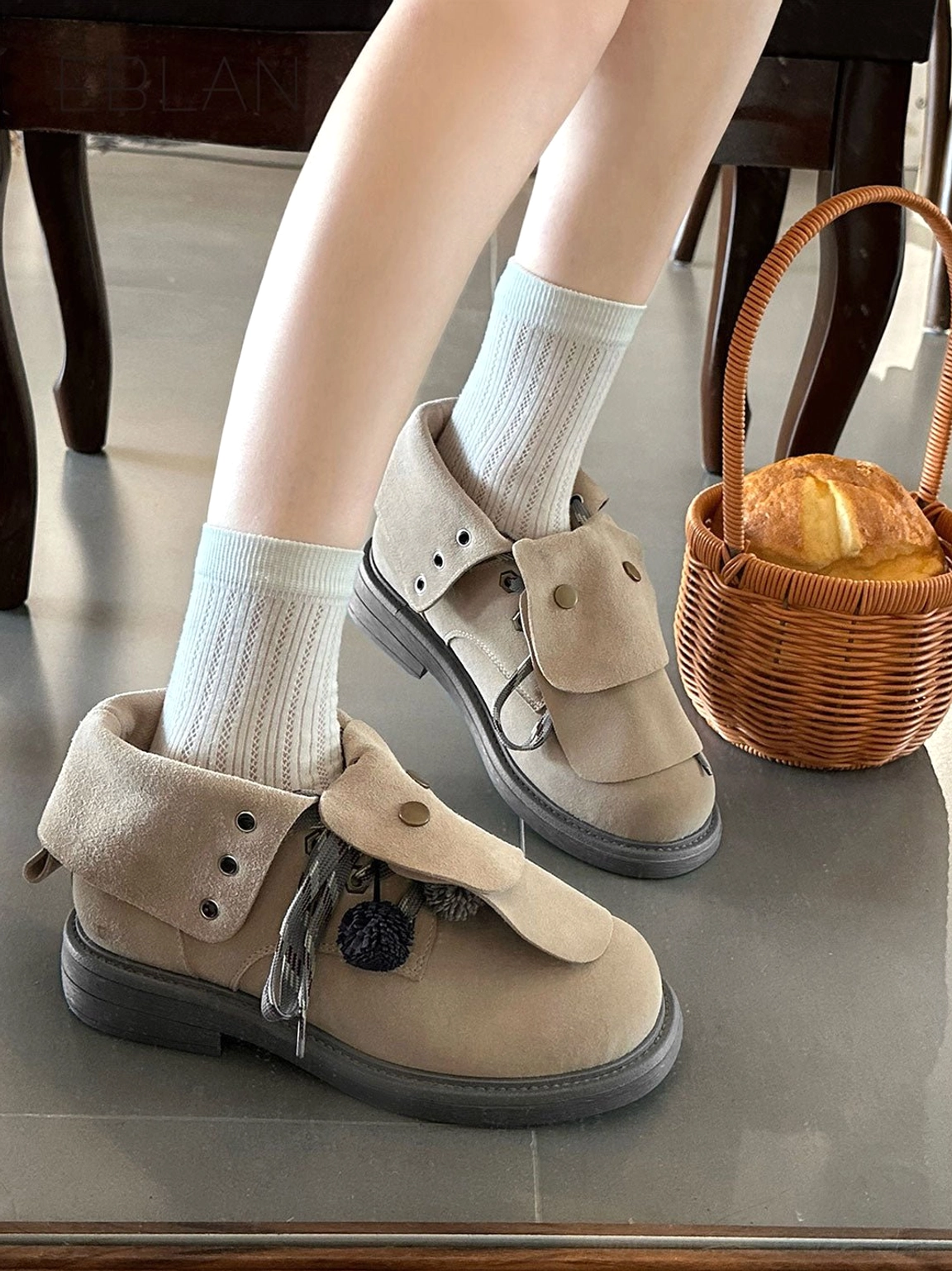 Y2K-inspired tassel-flap lace-up ankle boots with soft suede-look texture, decorative pom-poms, and a warm vintage color palette