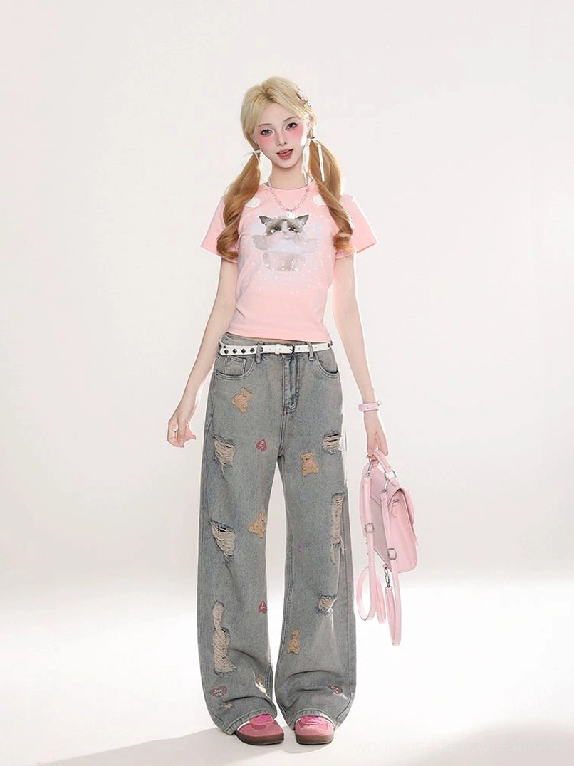 Full body Y2K streetwear outfit featuring distressed teddy bear wide-leg jeans, pink graphic tee, pink handbag, and pink flat shoes