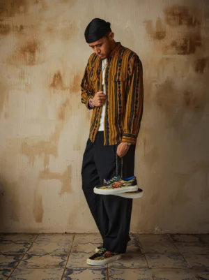 Model wearing yellow colorful abstract print canvas skate shoes with white socks and relaxed streetwear outfit