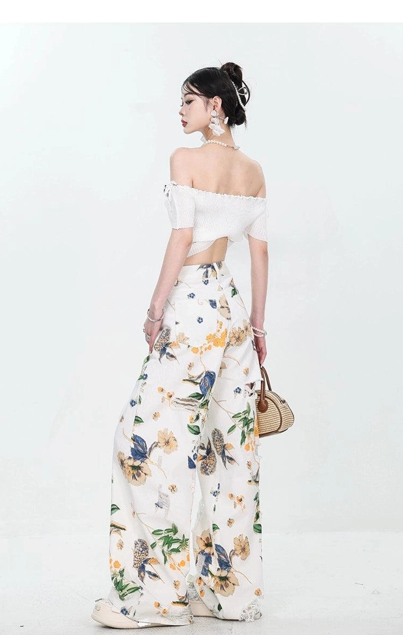 Full back view of high-waisted yellow and blue floral distressed wide-leg jeans