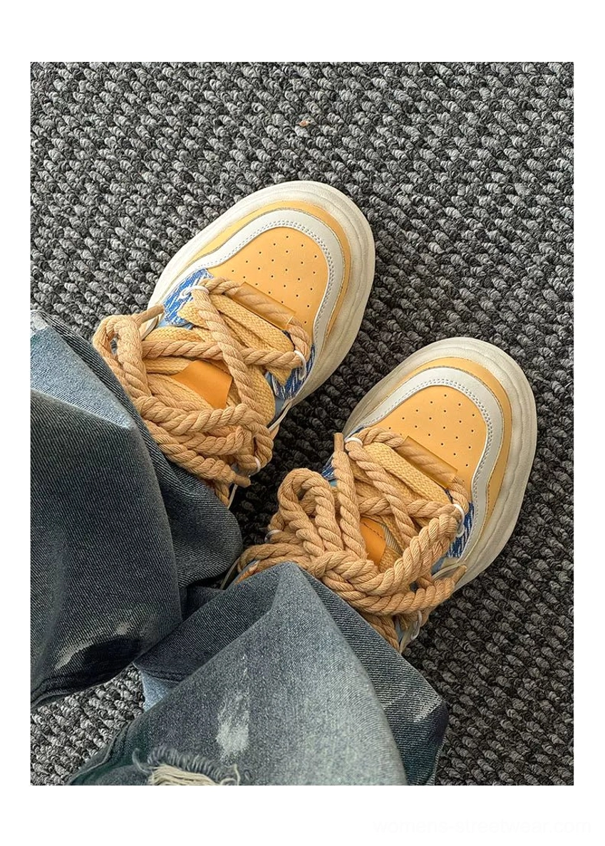 Yellow-brown and denim-blue paneled platform sneakers with thick rope laces, viewed with relaxed blue jeans in a contemporary casual outfit
