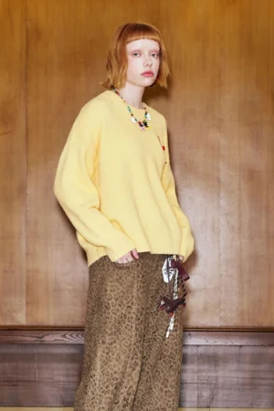 Three-quarter view of yellow crewneck cat embroidered sweater with loose sleeves and leopard print streetwear styling