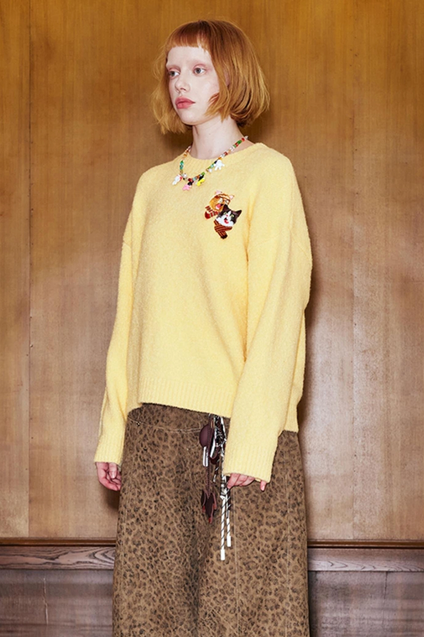 Yellow cat embroidered knit sweater styled with leopard print wide-leg pants in a relaxed Korean streetwear outfit