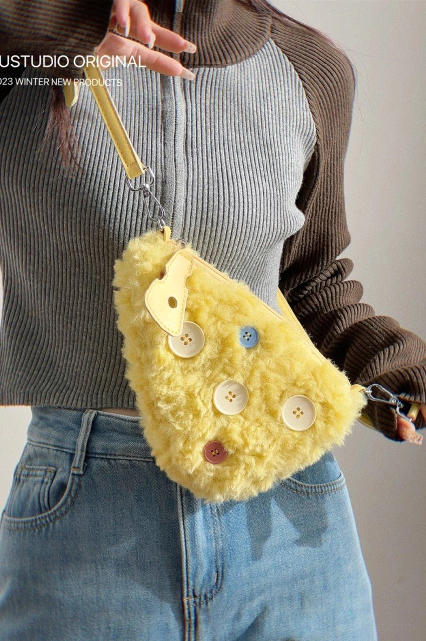 Yellow fuzzy cheese crossbody mini bag side-front wearing view showing plush texture and sculptural leather-look trim