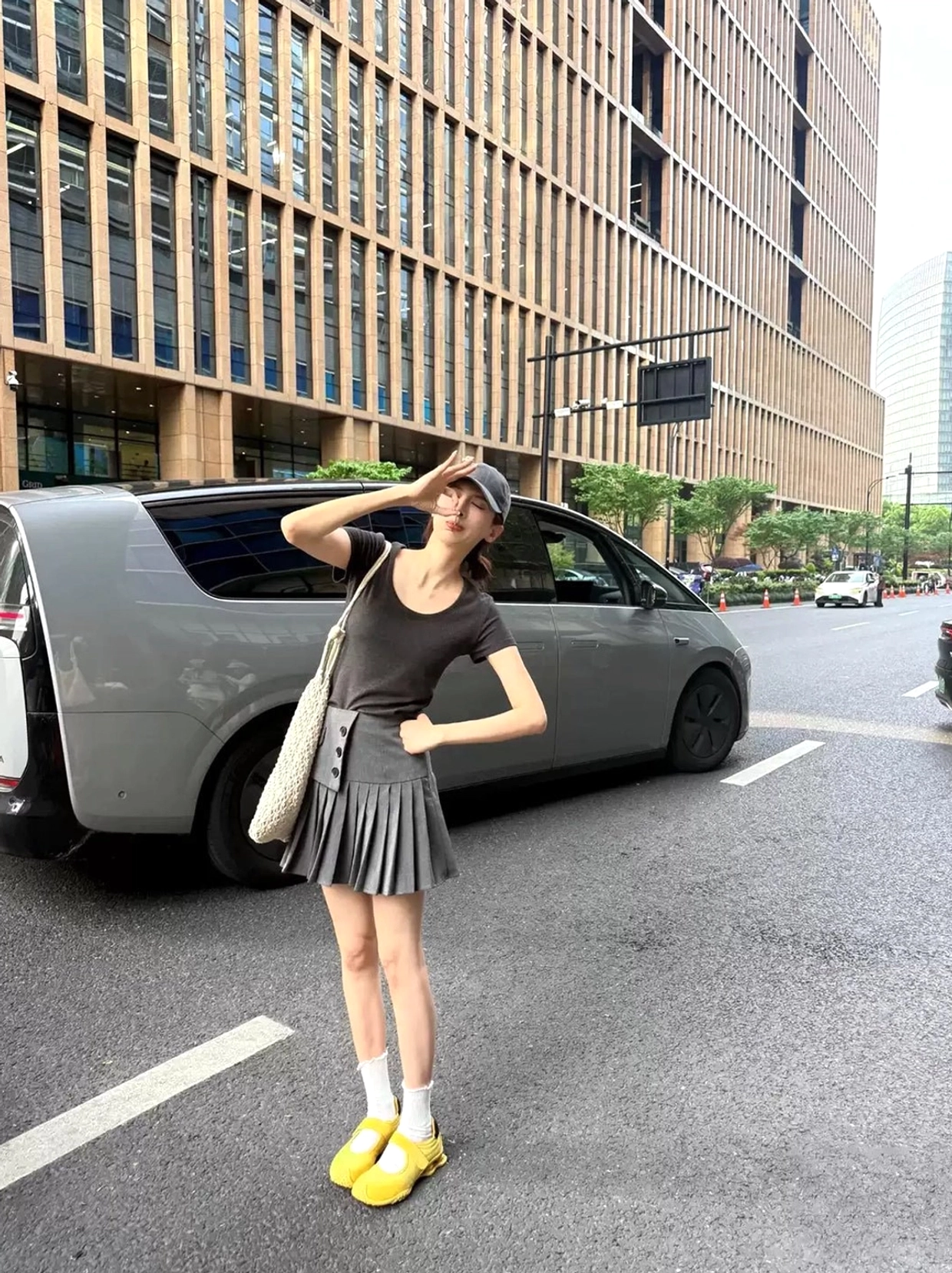 Yellow hook-and-loop Mary Jane air cushion ballet trainers styled with white socks and a grey pleated skirt in a Seoul fashion inspired urban streetwear look