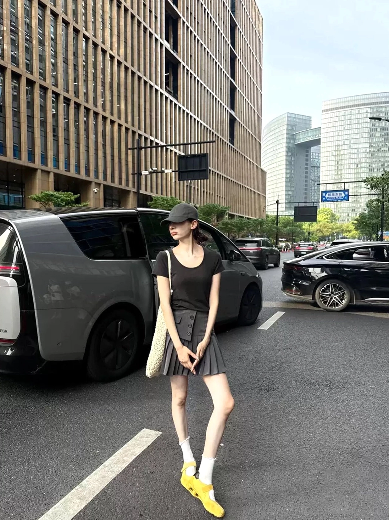 Yellow Mary Jane air cushion ballet trainers worn with white crew socks, a grey pleated mini skirt, and black top for a Seoul-inspired urban streetwear outfit