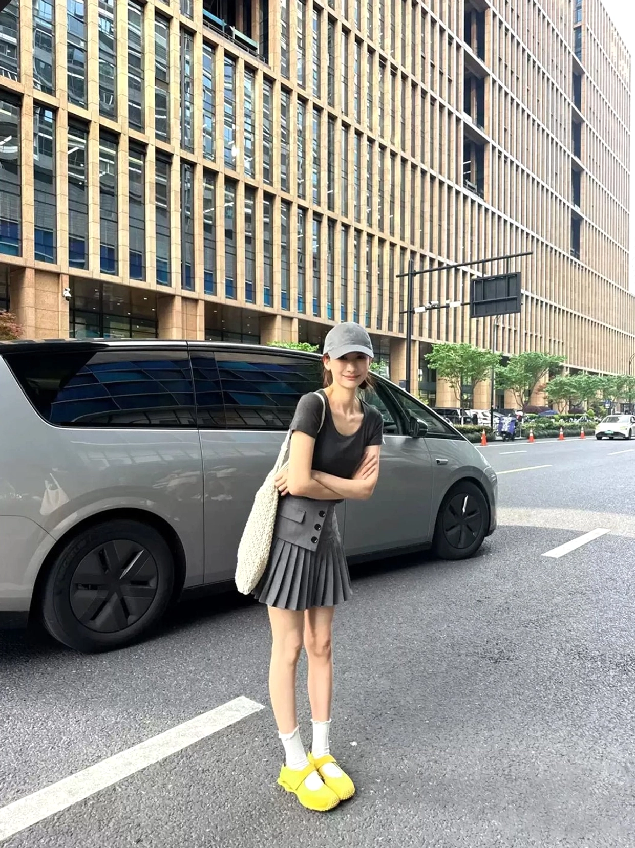 Close front three-quarter street view of yellow Mary Jane ballet trainers with adjustable strap, rounded toe, sculpted air-cushion sole, and white crew socks