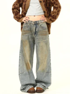 Women's vintage wash yellow mud dye wide-leg distressed jeans with high waist and relaxed floor-length silhouette front view