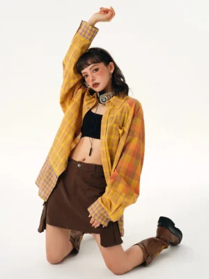 Yellow plaid oversized button-up shirt with orange and lilac contrast sleeve panels styled in a Korean streetwear outfit