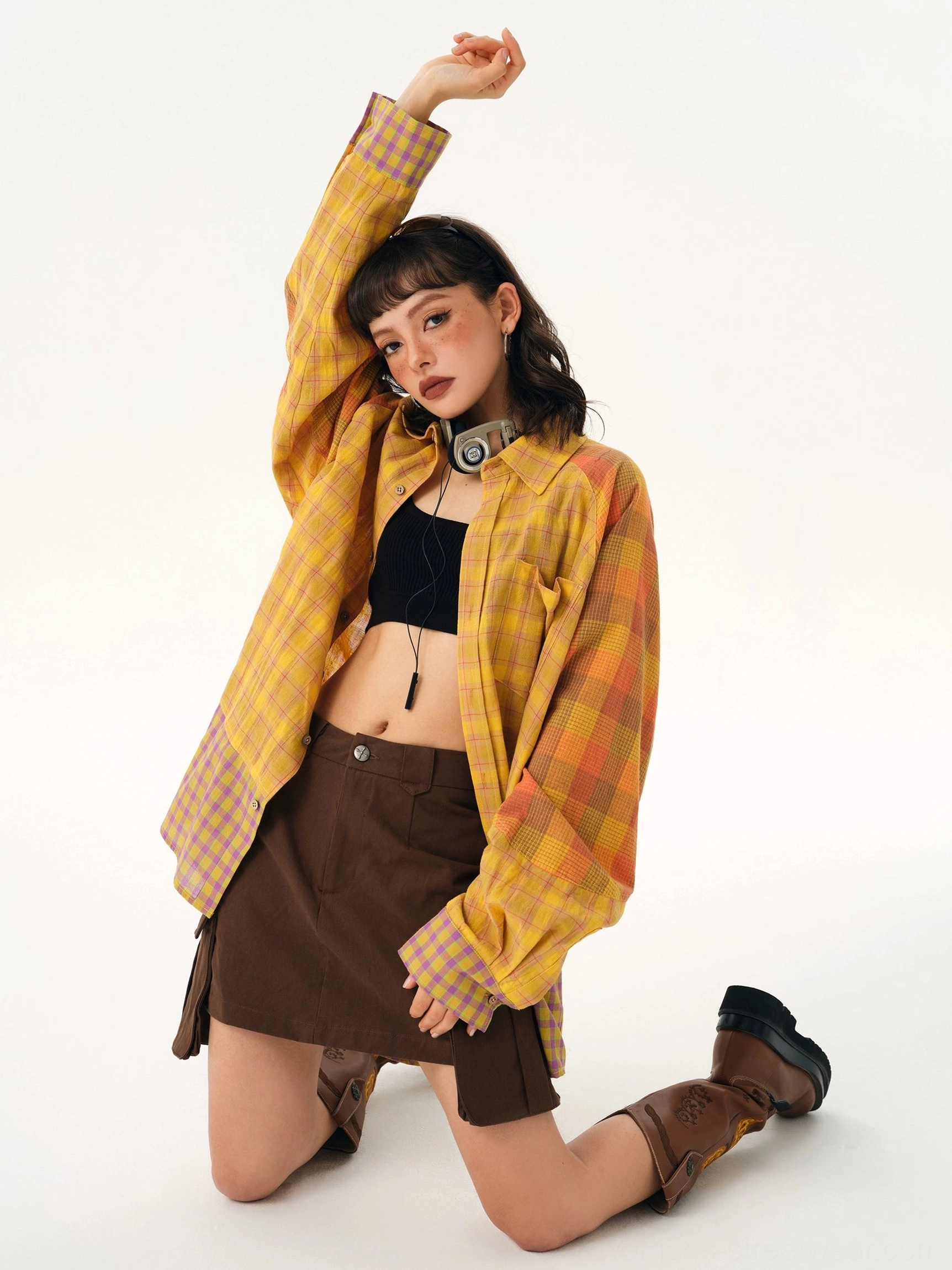 Yellow plaid oversized button-up shirt with orange and lilac contrast sleeve panels styled in a Korean streetwear outfit