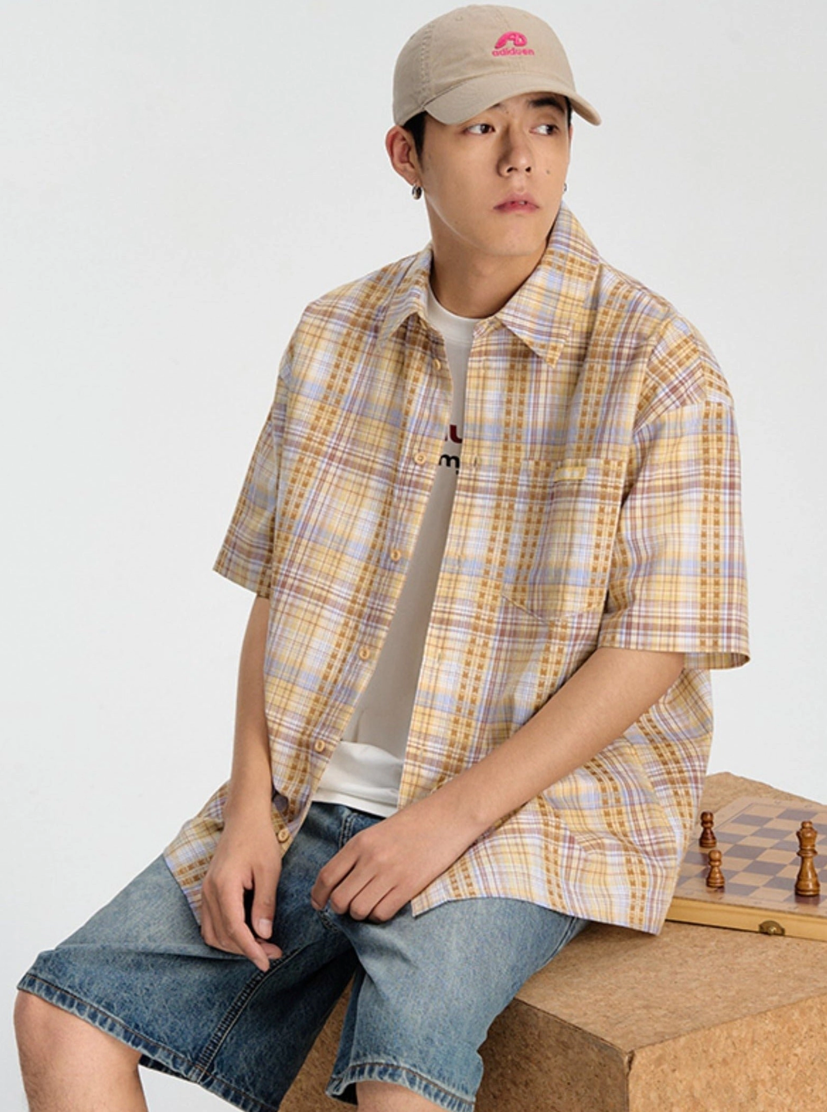Yellow plaid short sleeve streetwear shirt styled with denim shorts and a white inner T-shirt in a casual summer outfit