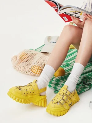 Model wearing yellow punk platform sandals with white crew socks in a casual summer streetwear outfit