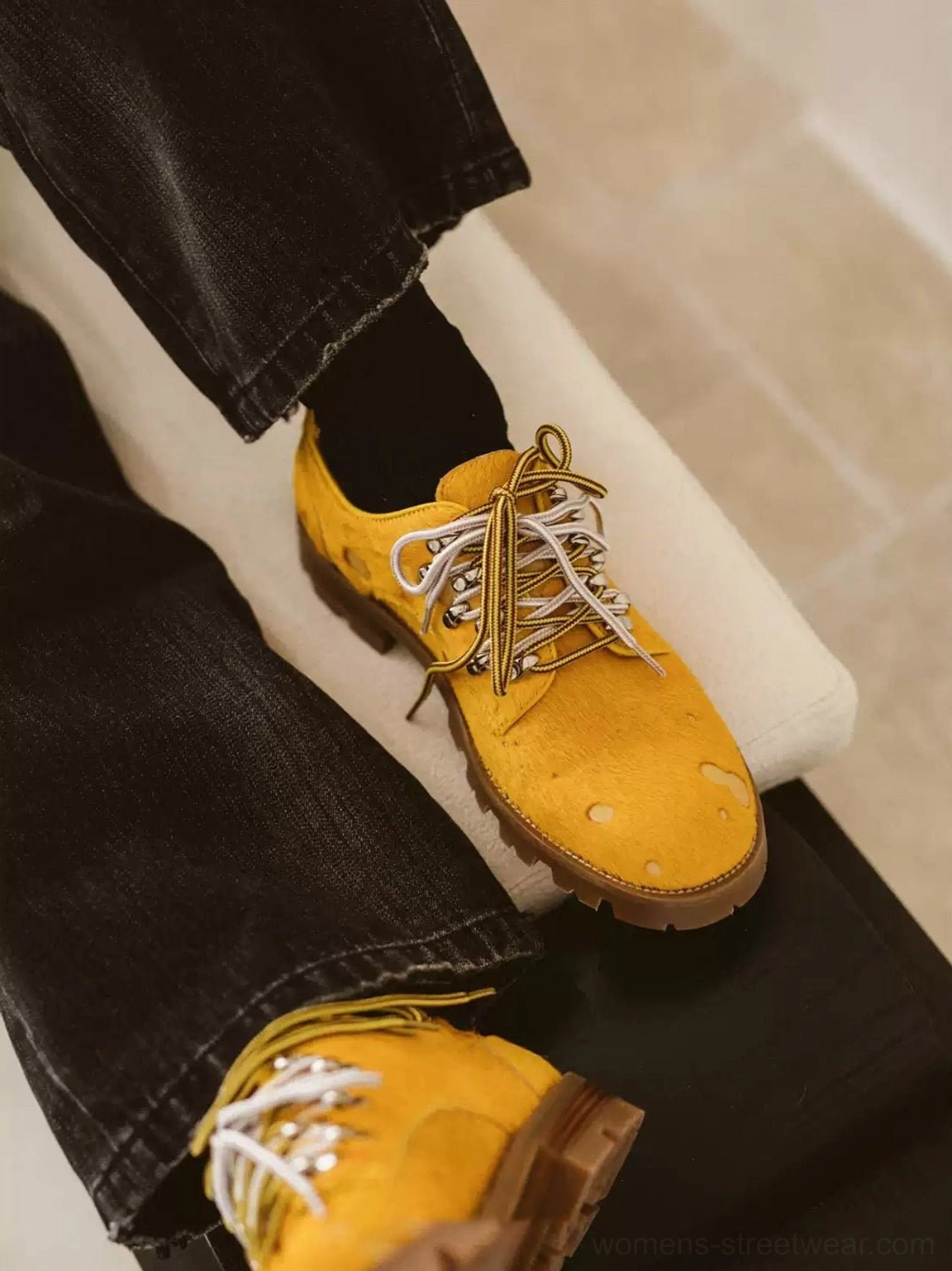Yellow spotted pony hair effect Derby shoes worn with black denim jeans and black socks in an indoor streetwear outfit