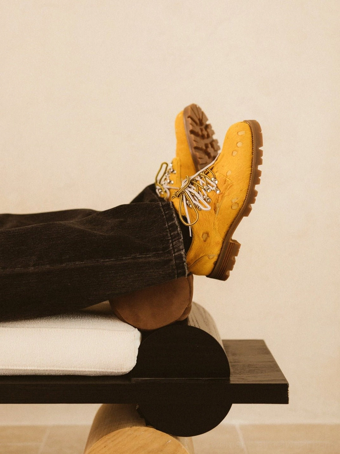 Rear worn view of yellow spotted pony hair effect Derby shoes showing the thick lugged rubber outsole and black denim styling