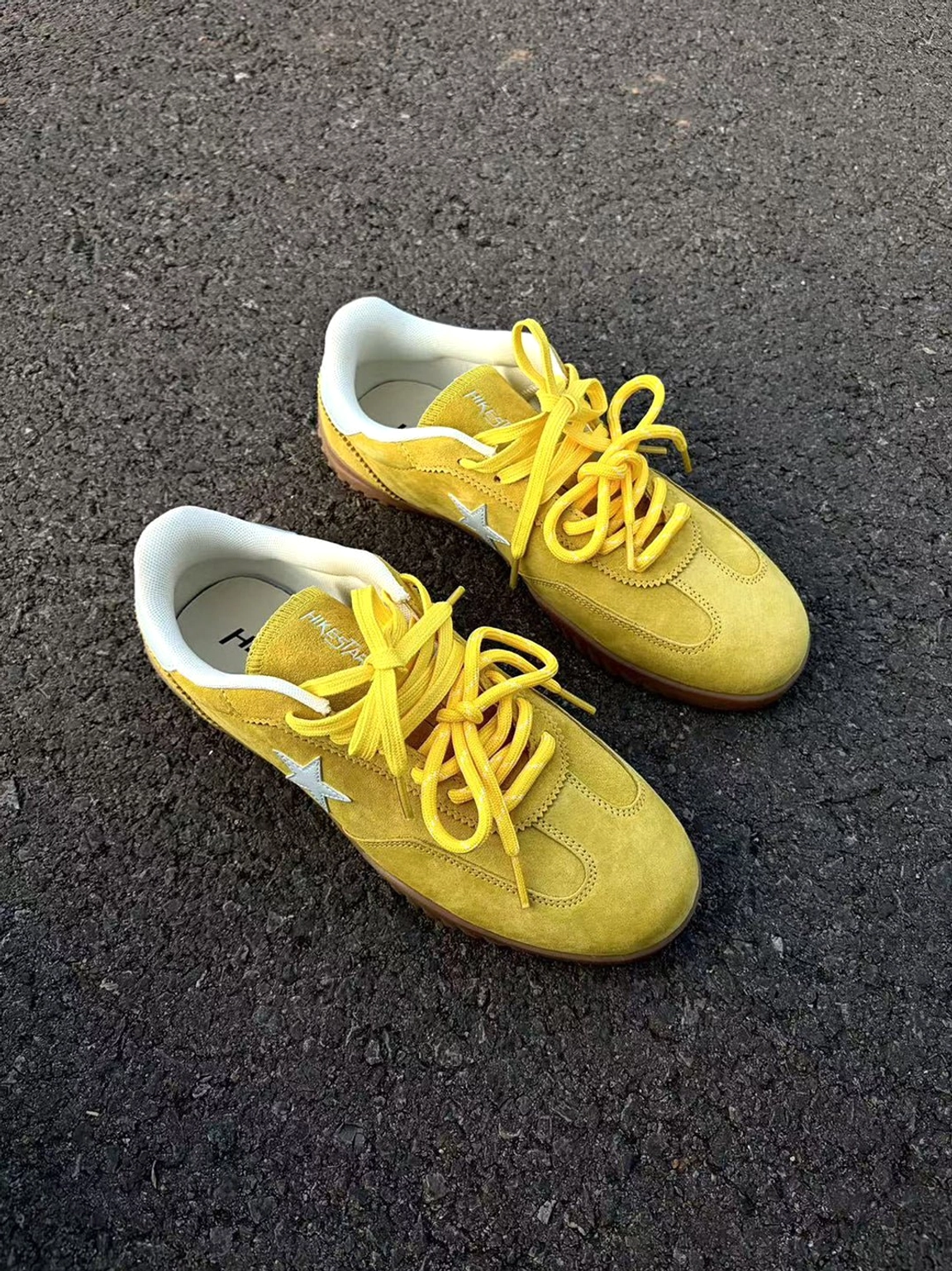 Yellow suede star-embroidered streetwear trainers displayed as a retro-inspired low-profile unisex sneaker design