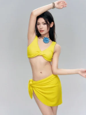 Yellow textured twist-front bikini set with matching self-tie wrap sarong skirt shown in a three-quarter front studio view