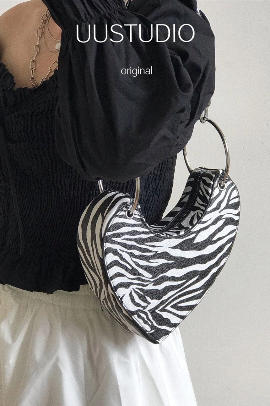 Side view of zebra print heart mini bag with silver metal chain hardware