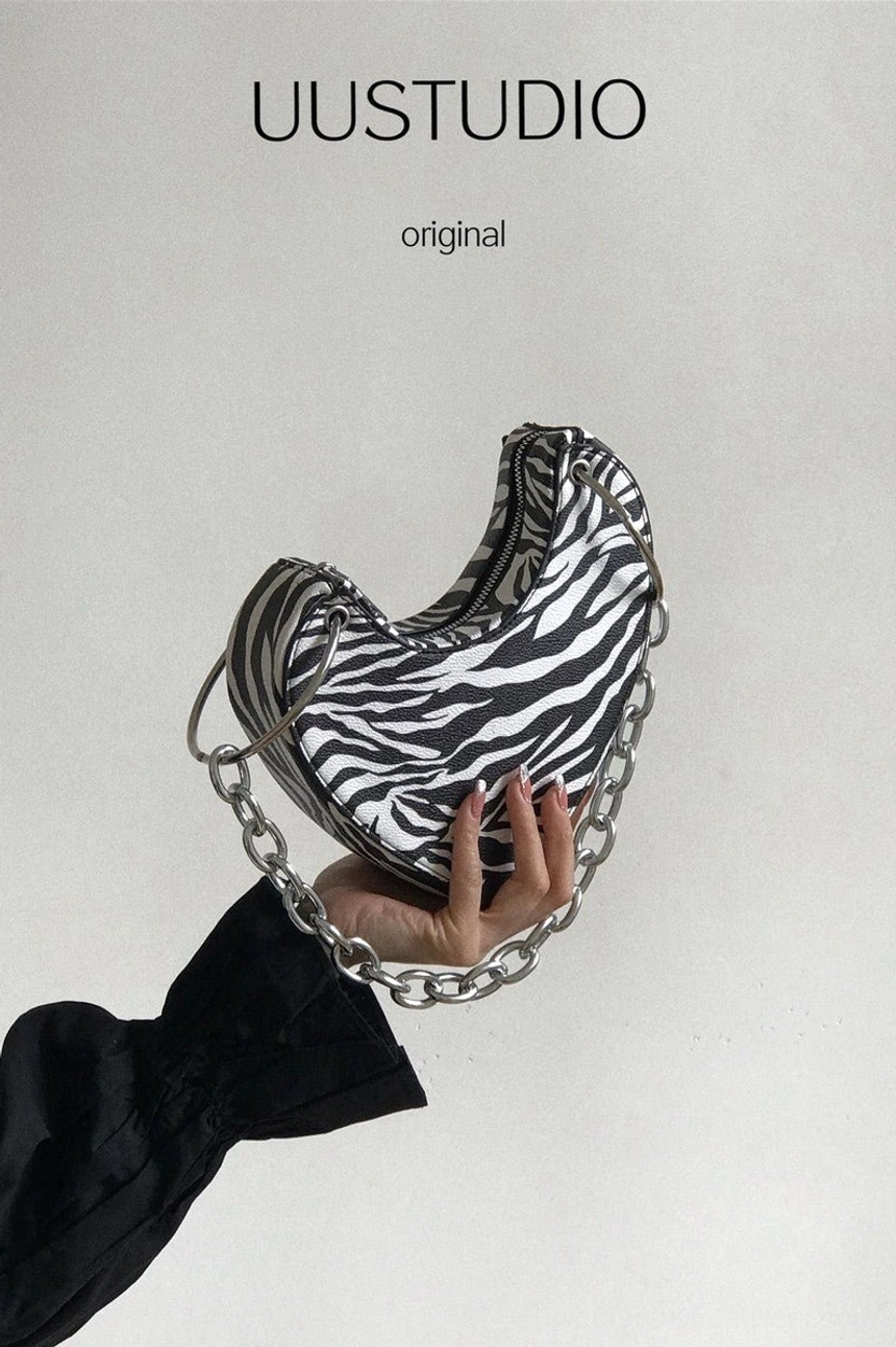 Close-up of zebra print heart-shaped chain mini bag with chunky silver chain