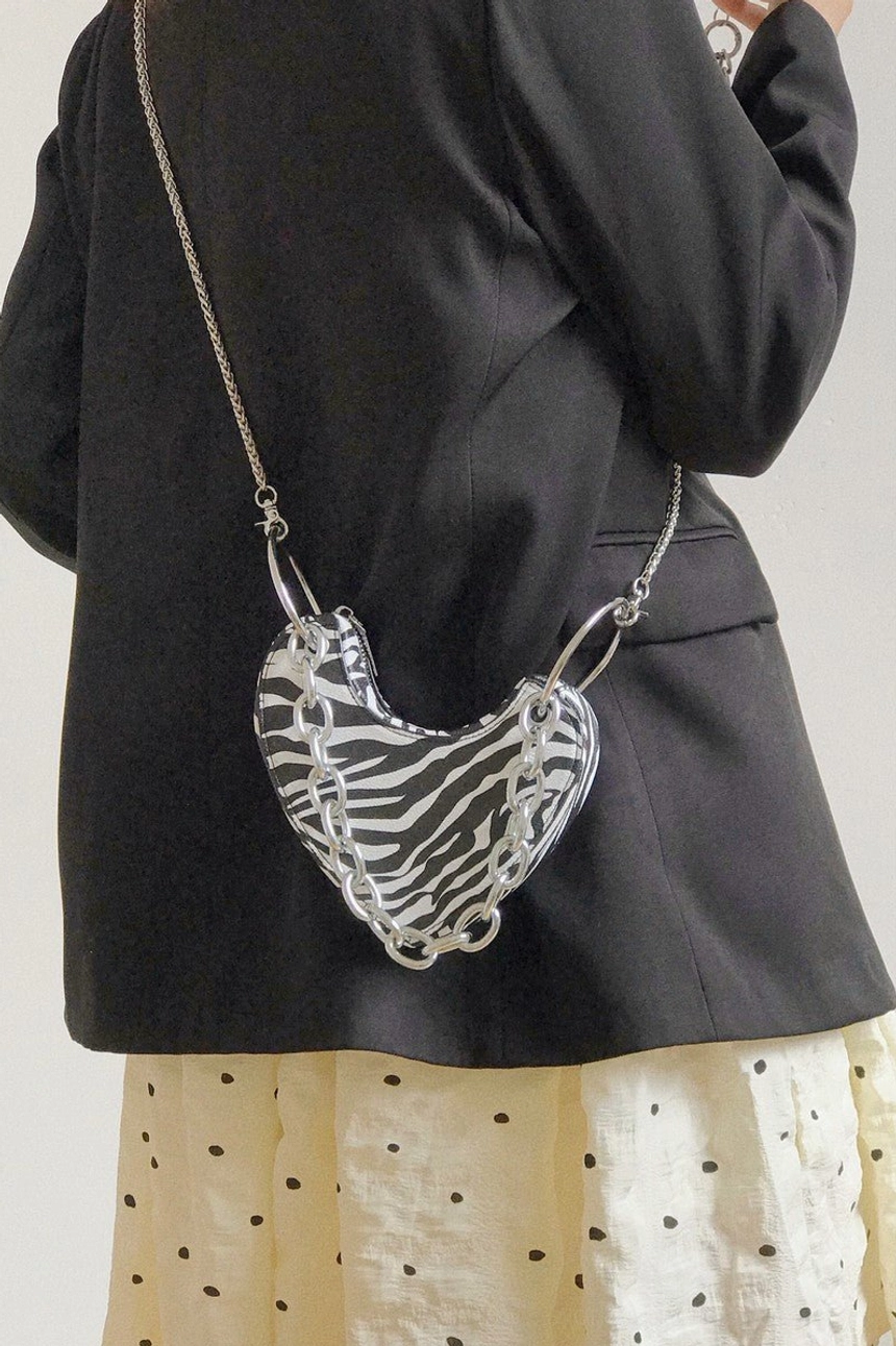 Zebra print heart-shaped mini bag worn crossbody with silver chain strap